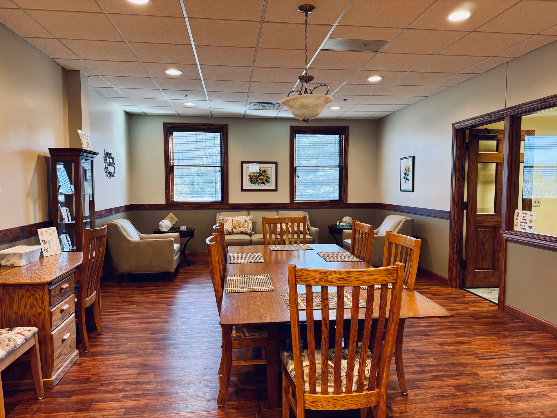 A warm dining room with a large wooden table and comfortable seating along the back wall.