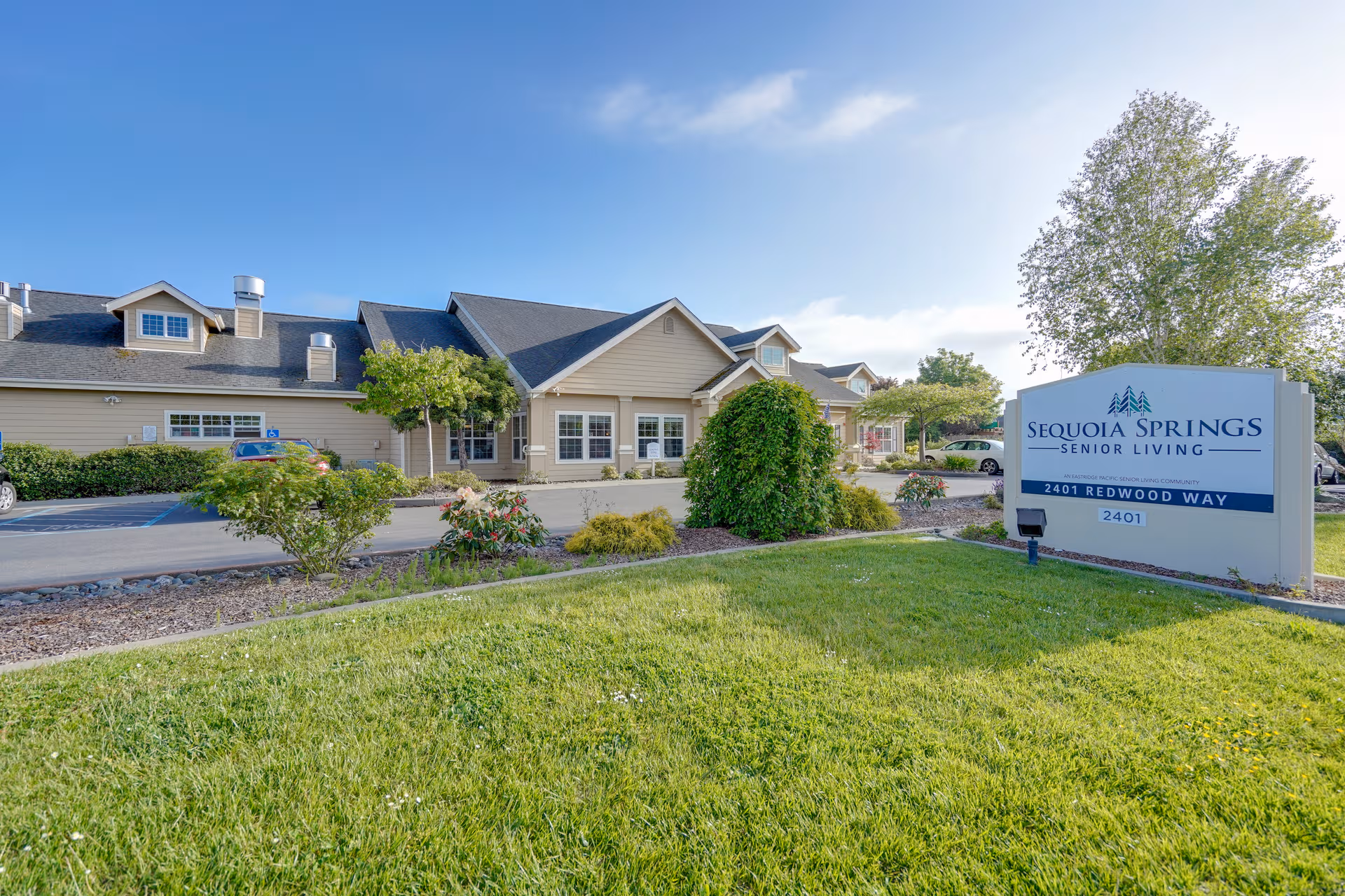 Front exterior of Sequoia Springs Senior Living Community with sign and landscaping.