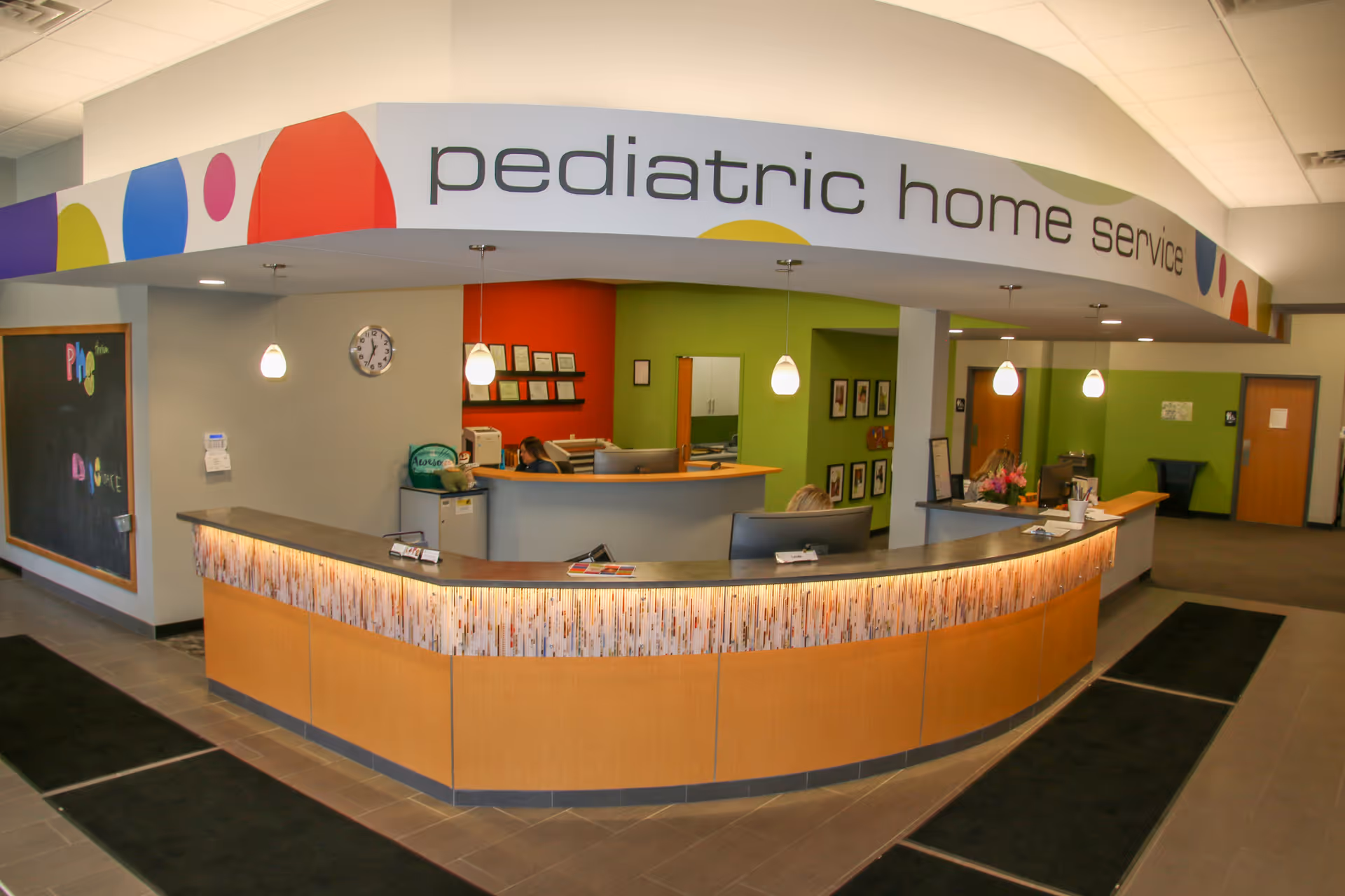 Lobby reception desk with curved counter at Pediatric Home Service Minneapolis office.