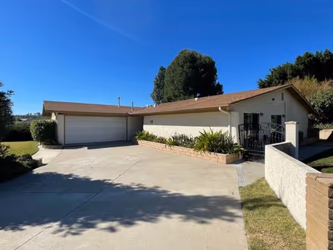 Front exterior of a single-story senior care home with driveway and garage.