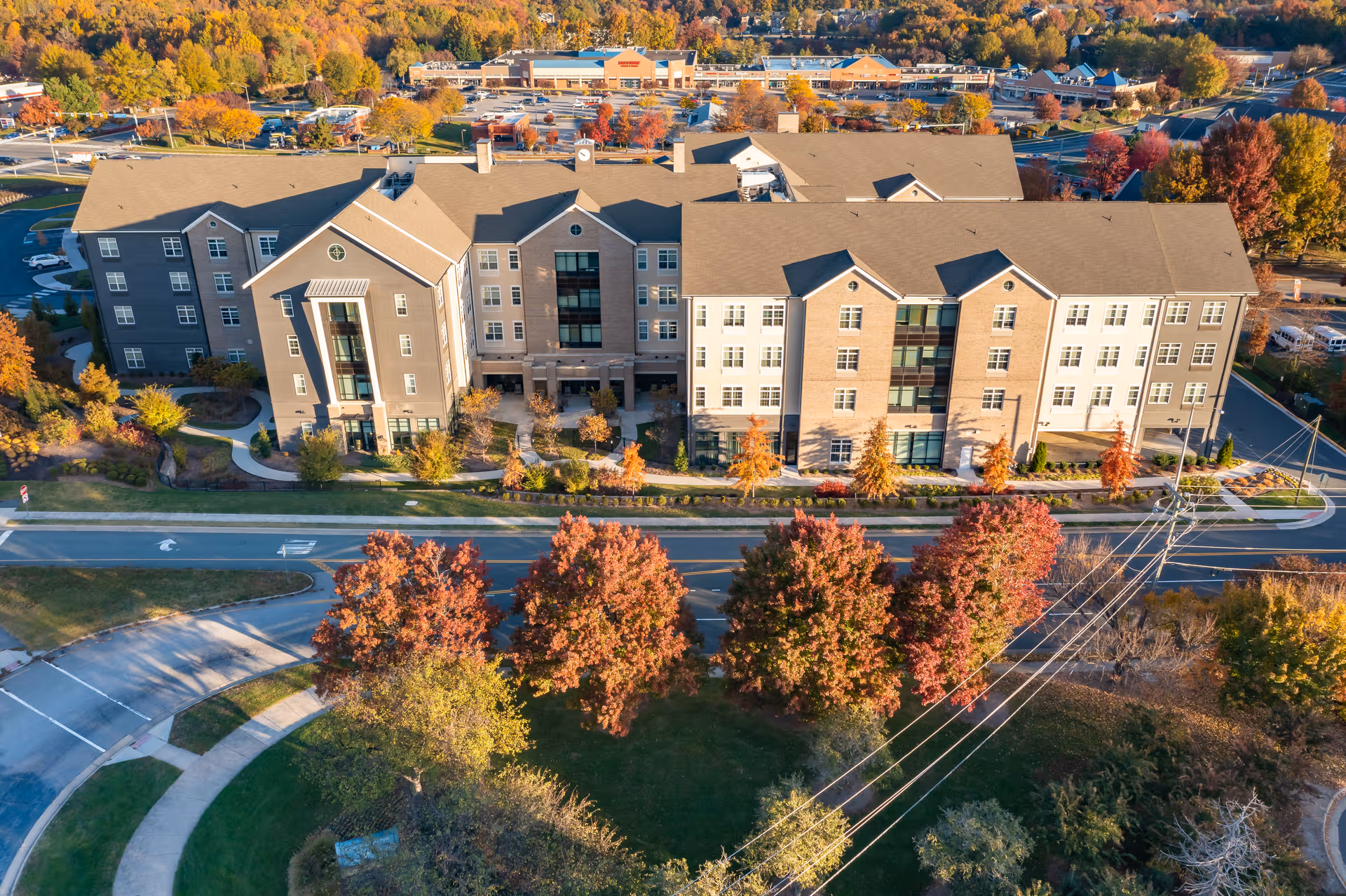 Aerial view of a large senior living campus with fall-colored trees along the front