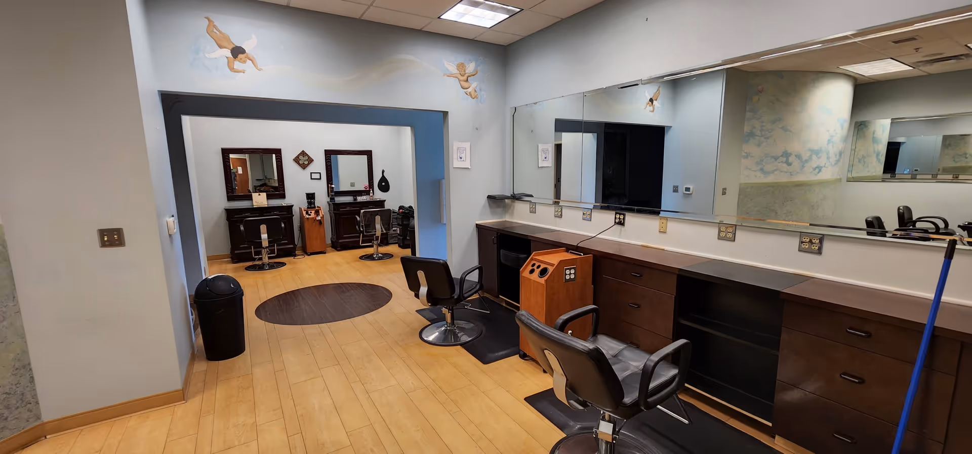 Interior view of a senior living facility hair salon with mirrors and styling chairs.