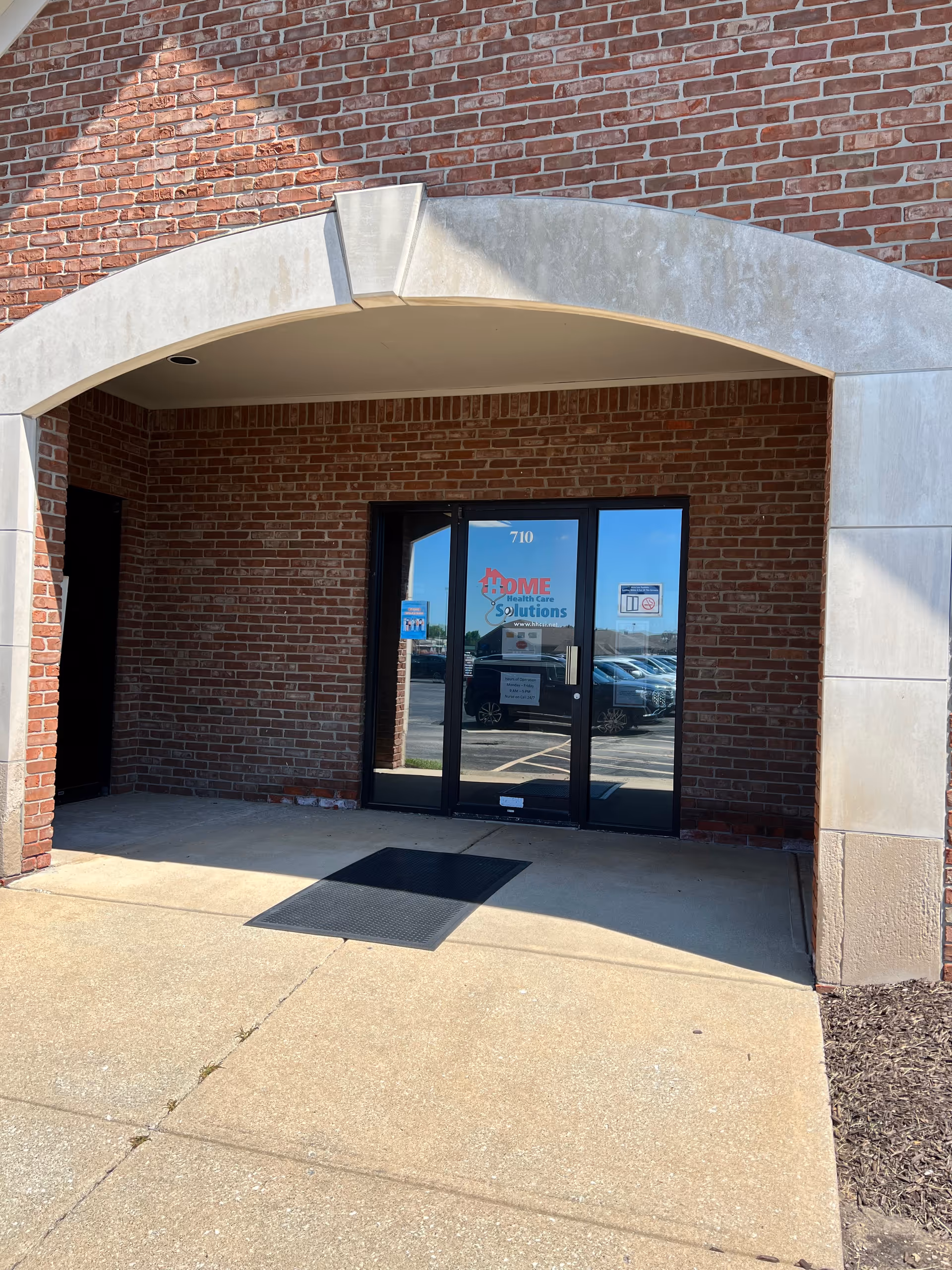 Brick exterior with arched entrance and glass doors labeled Home Health Care Solutions LLC.