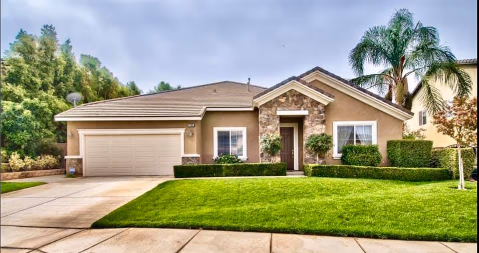 Front view of a single-story assisted living home with a manicured lawn.