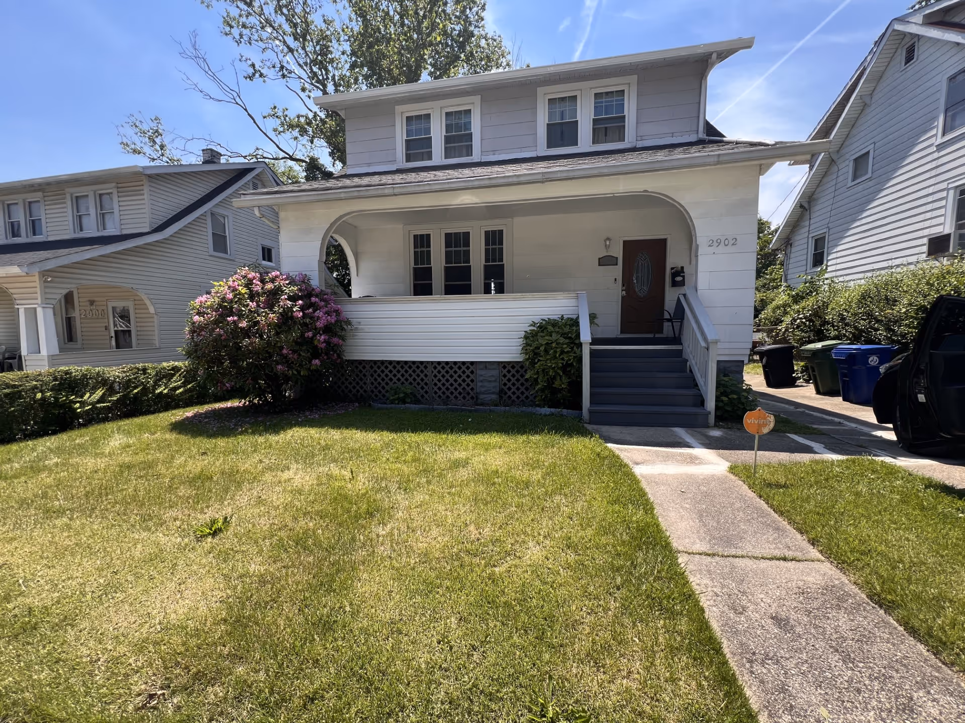 Front view of a residential building with a covered porch and steps.