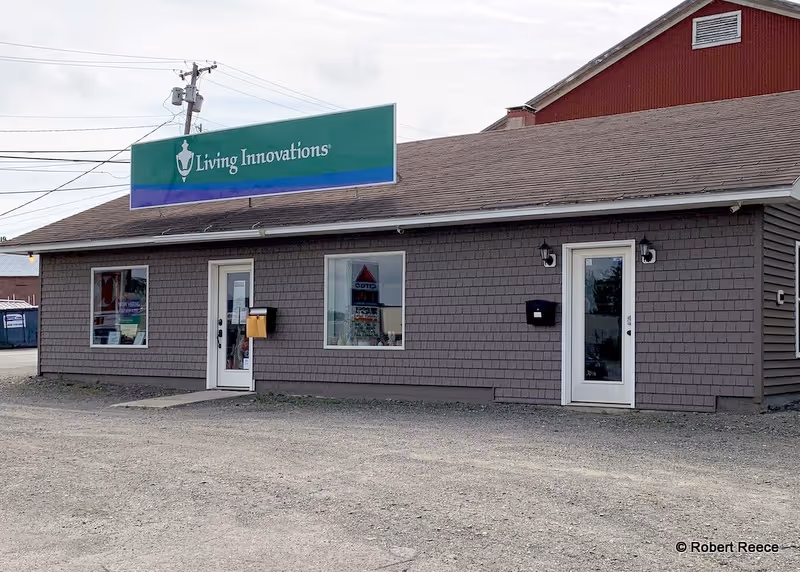 Exterior view of a brown building with a green Living Innovations sign.