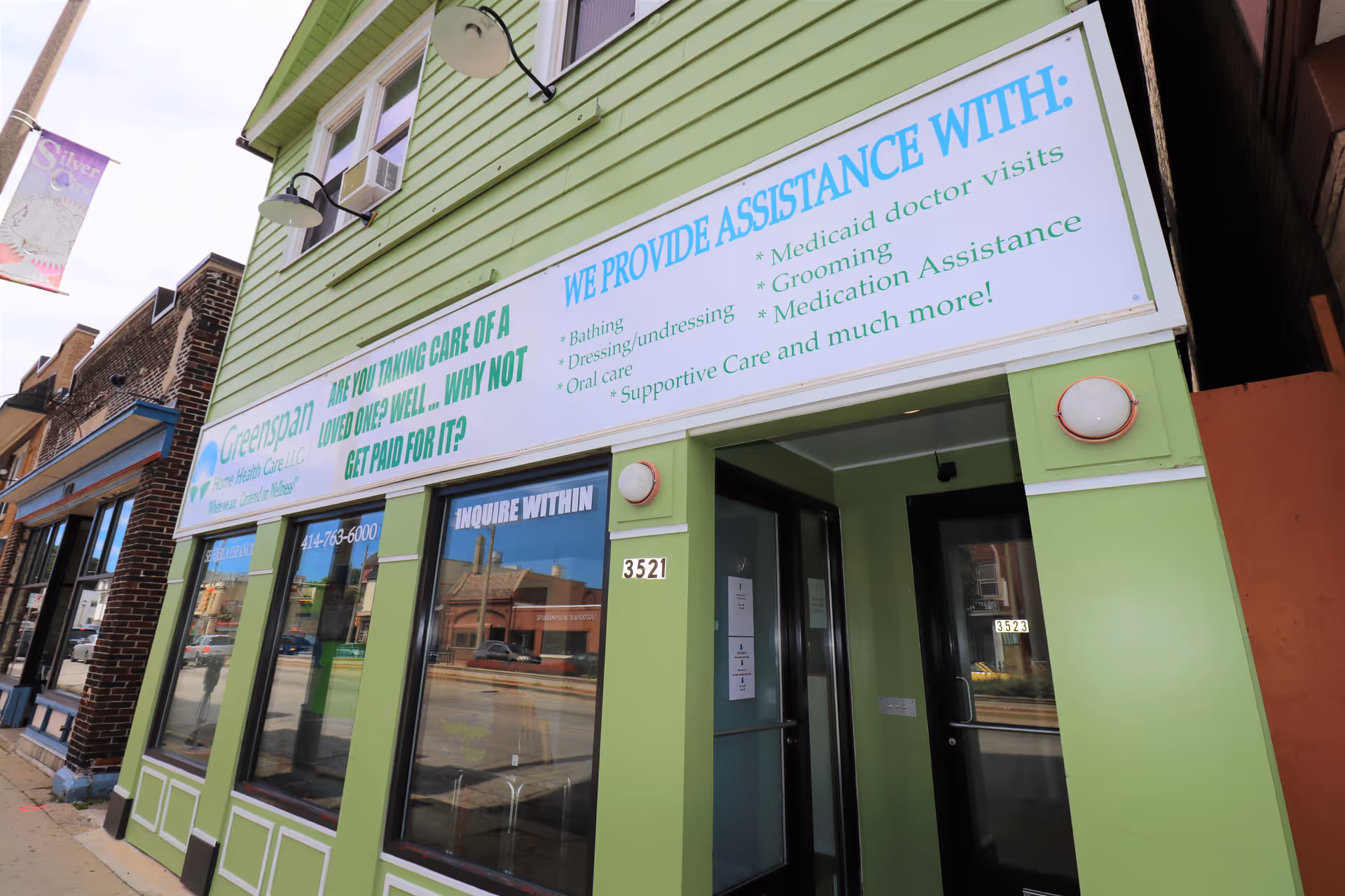 Green storefront with a large Greenspan Home Health Care sign on a green building.