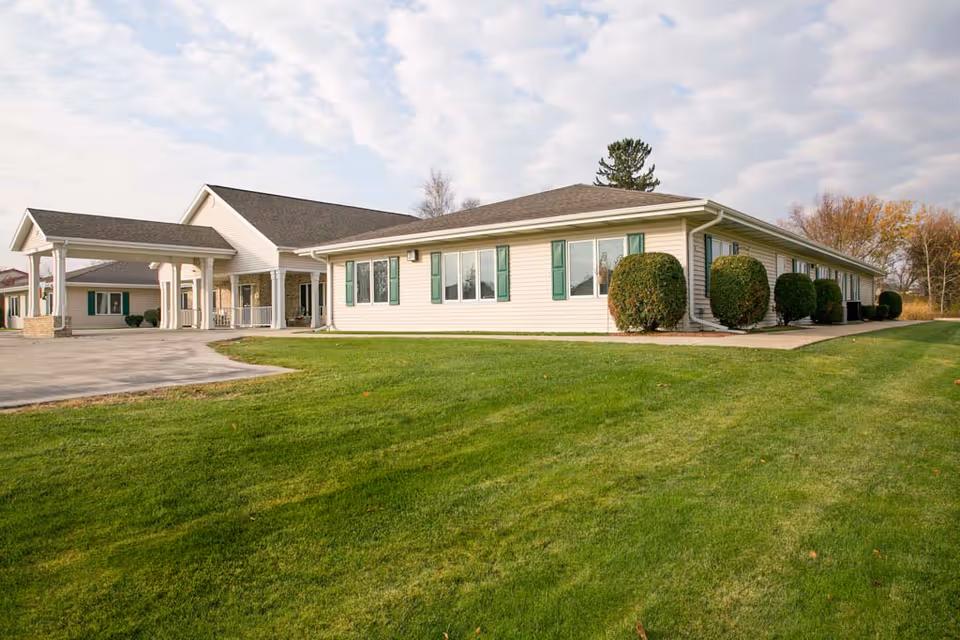 A single-story senior care facility with a green lawn and a covered entrance.
