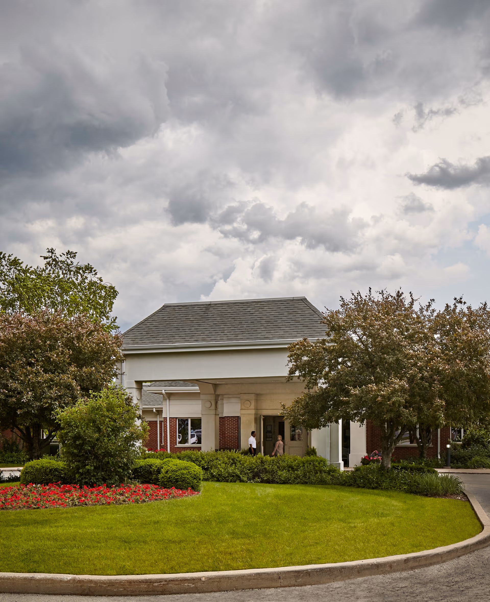 Exterior view of Alta Rehab at Oak Brook entrance with landscaping and pedestrians