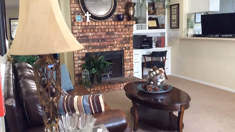 Cozy living room with brick fireplace, couch, coffee table, and entertainment area.