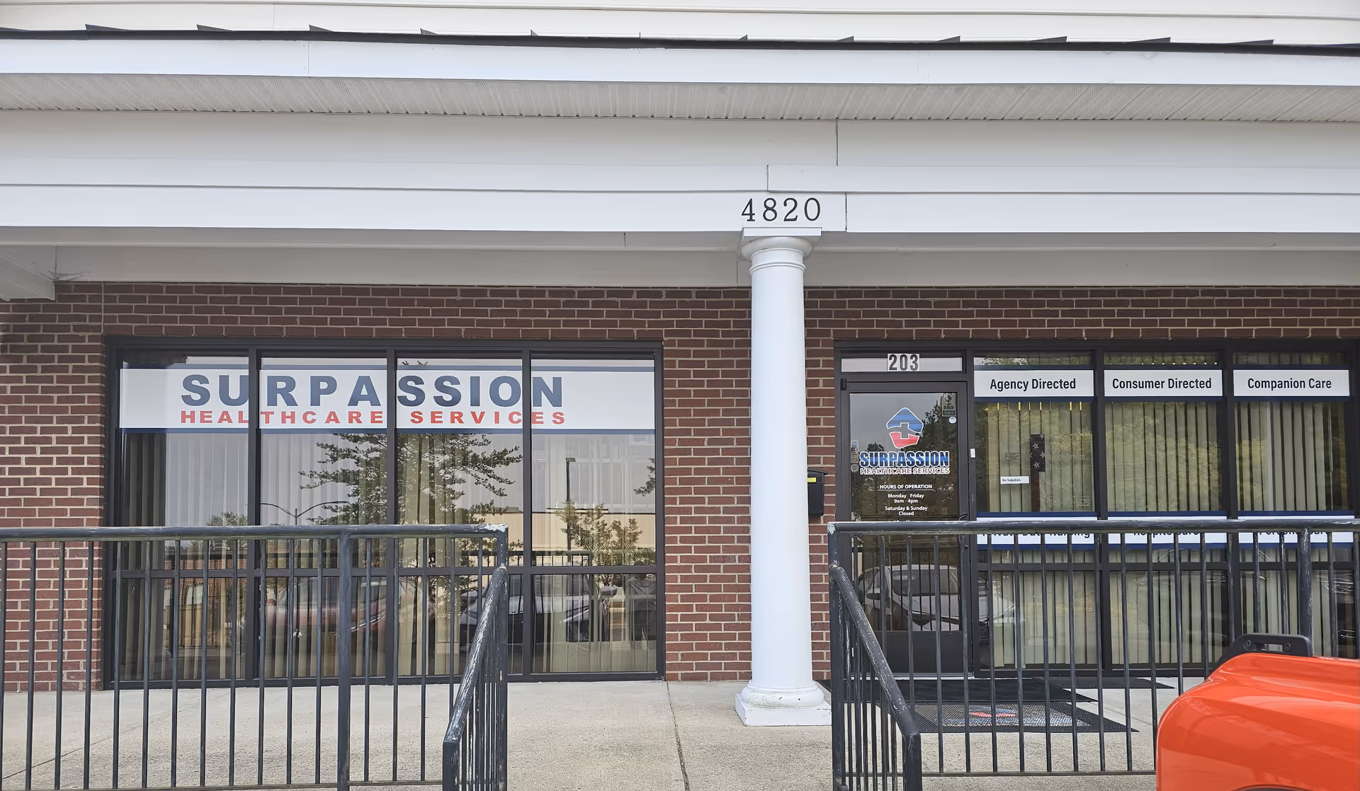 Exterior view of Surpassion Health Care Services building with brick facade and glass entrance doors.