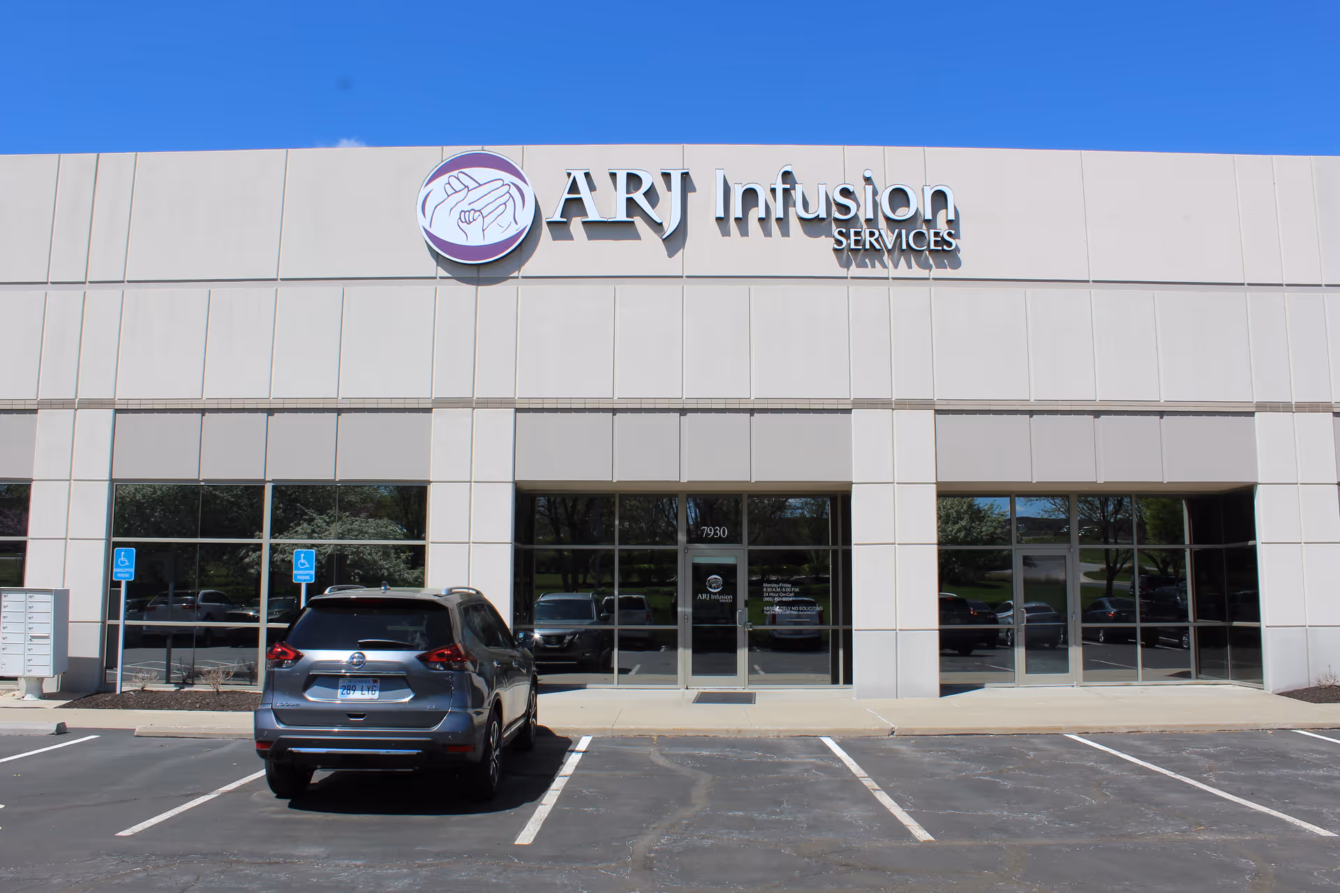 Front exterior of ART Infusion Services building with large windows and parking lot.