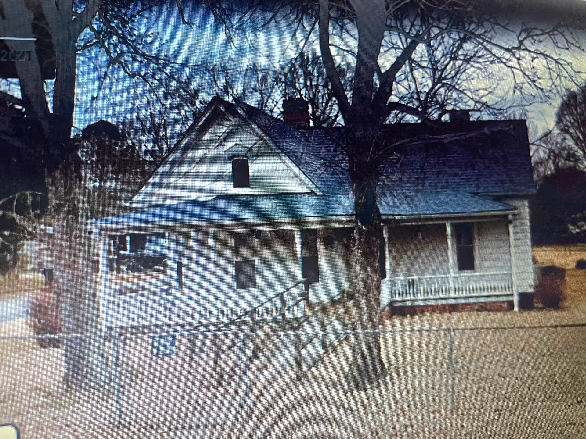 A single-story white building with a front porch and a wheelchair ramp.