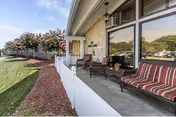 Front porch area of Windsor Care Center with striped chairs, railing, and landscaped lawn.