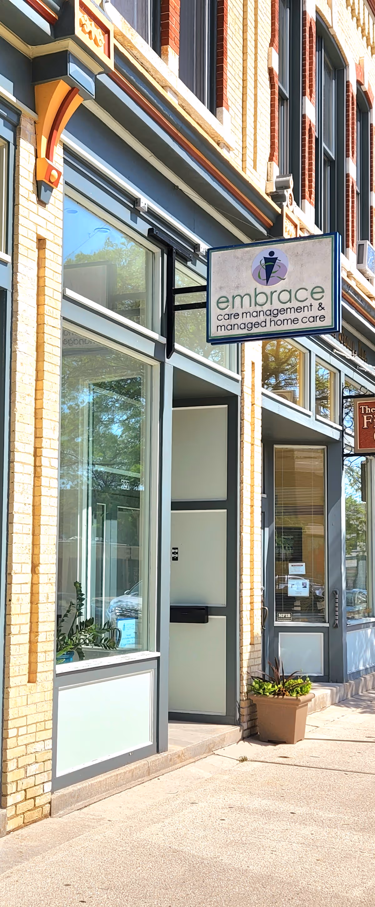 Exterior view of a brick building entrance with an Embrace care sign.