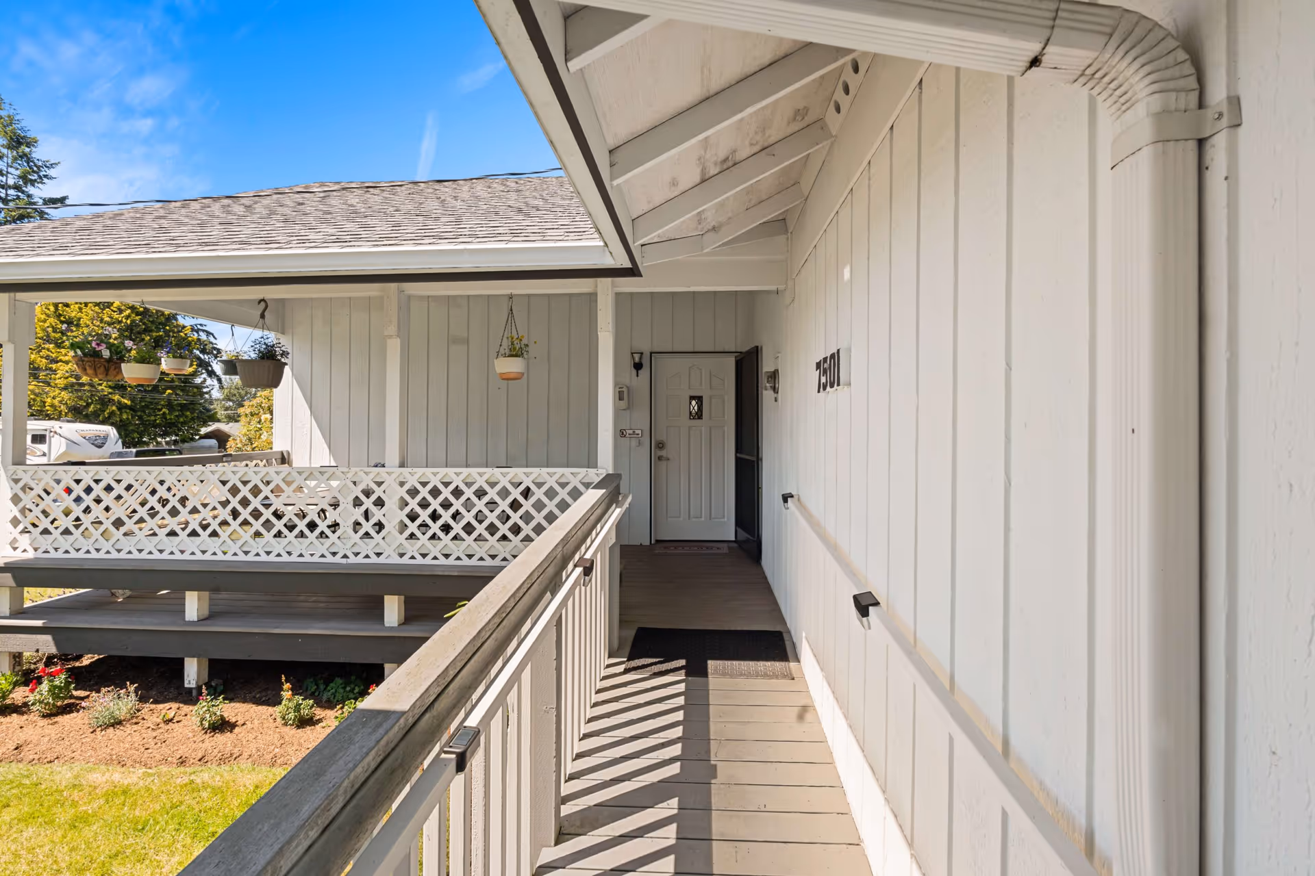 Front exterior entry of a white senior living home with a covered porch and railing.