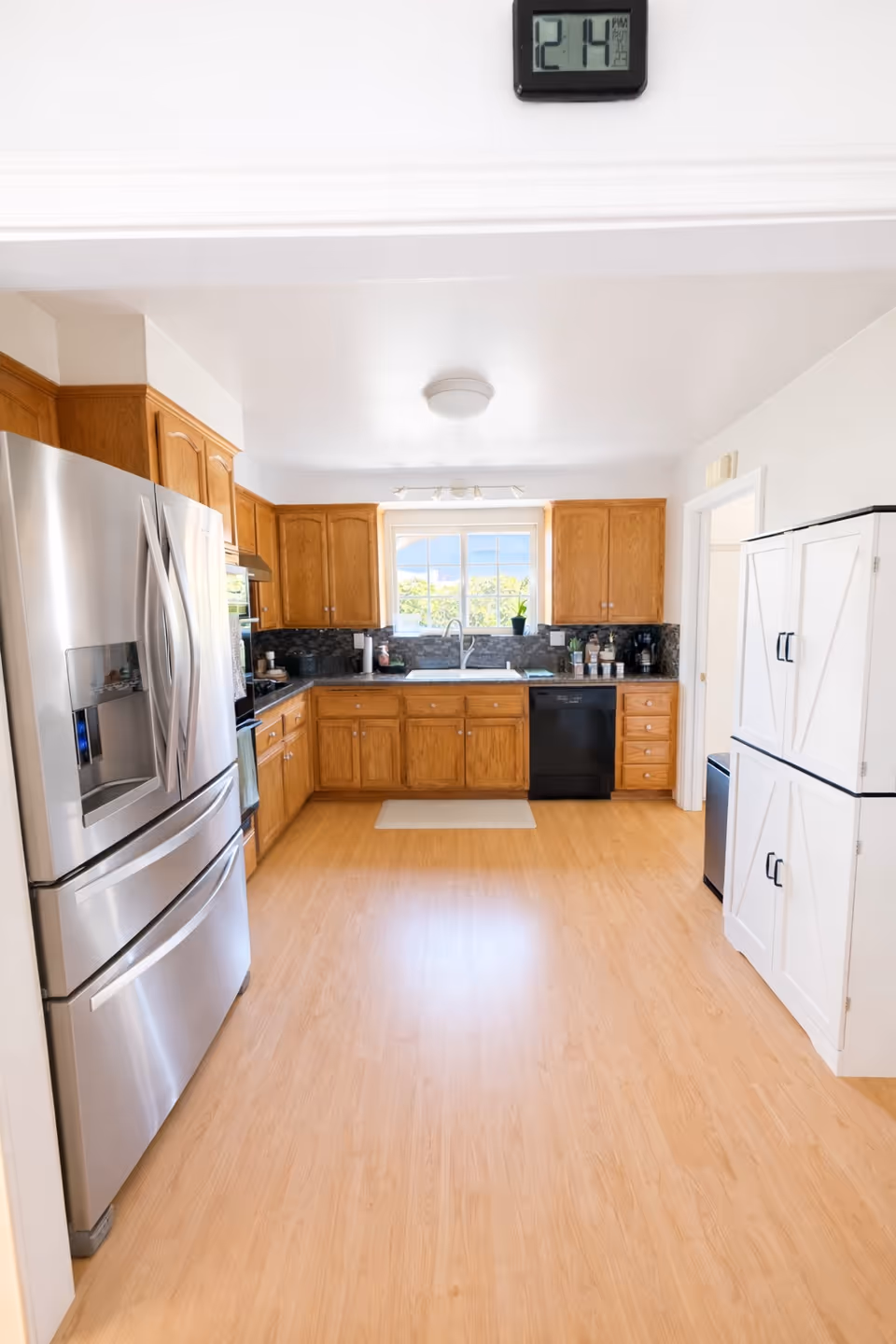 Bright kitchen with wooden cabinets, stainless appliances, and a windowed sink area.