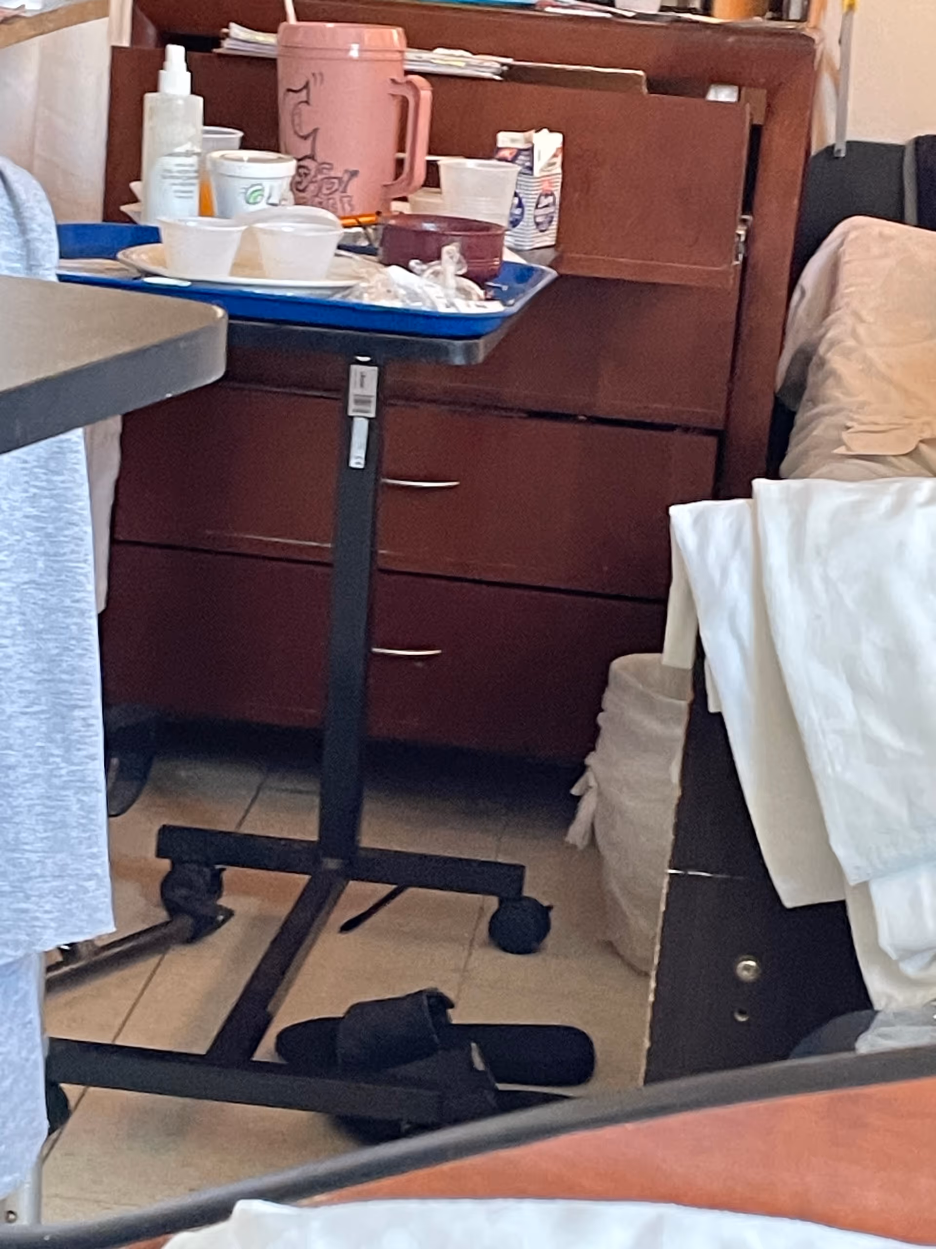 Interior care room with a mobile service cart, dishes, and supplies.