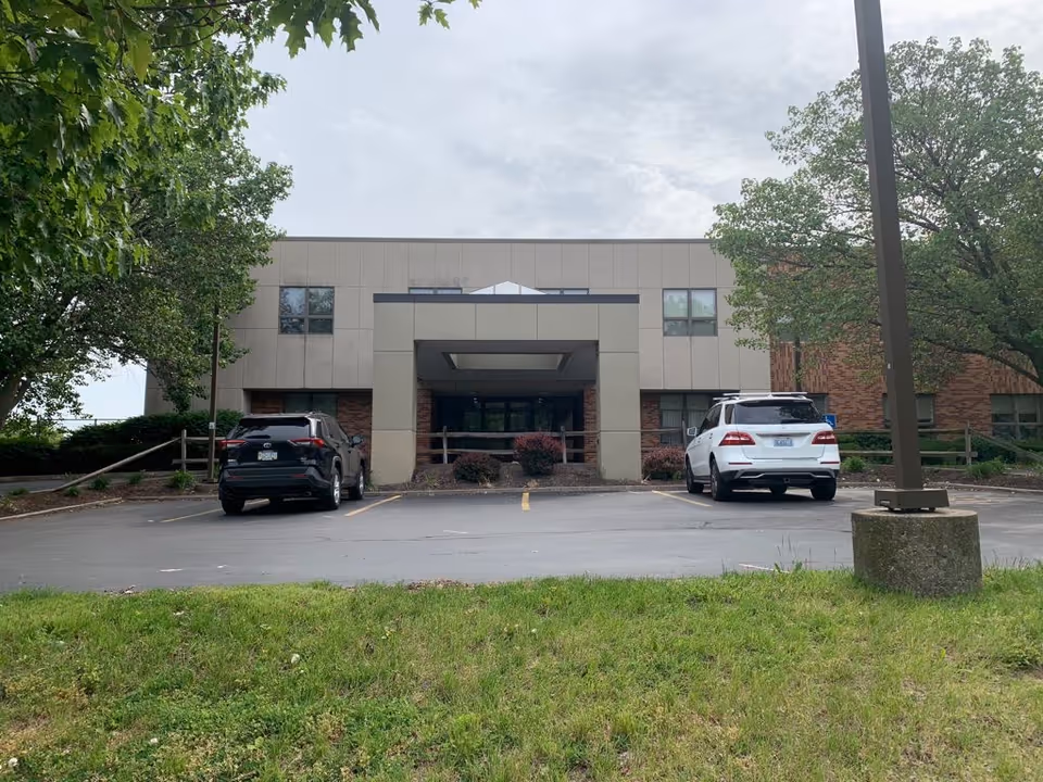 Front view of St Mary's Home of Erie with parked cars and trees.