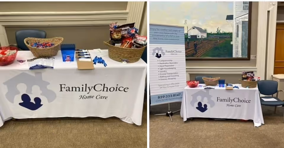 Two promotional tables with FamilyChoice Home Care branding, baskets, flyers, and a standing informational banner.