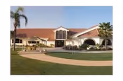 Exterior view of Stroud Health Care Center South with palm trees and curved pathway.