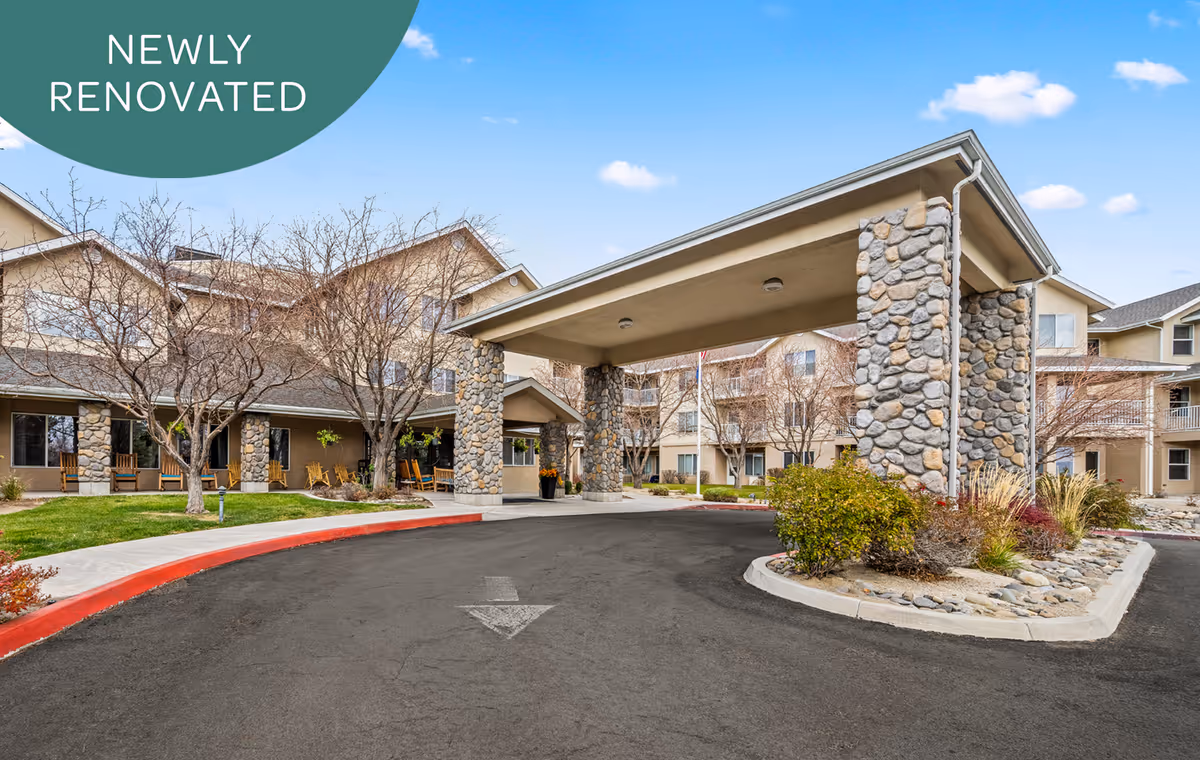 Newly renovated senior living facility exterior with stone pillars and a covered porte-cochere entrance.