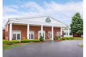 Life Care Center of Nashoba Valley exterior with white columns and a curved driveway.