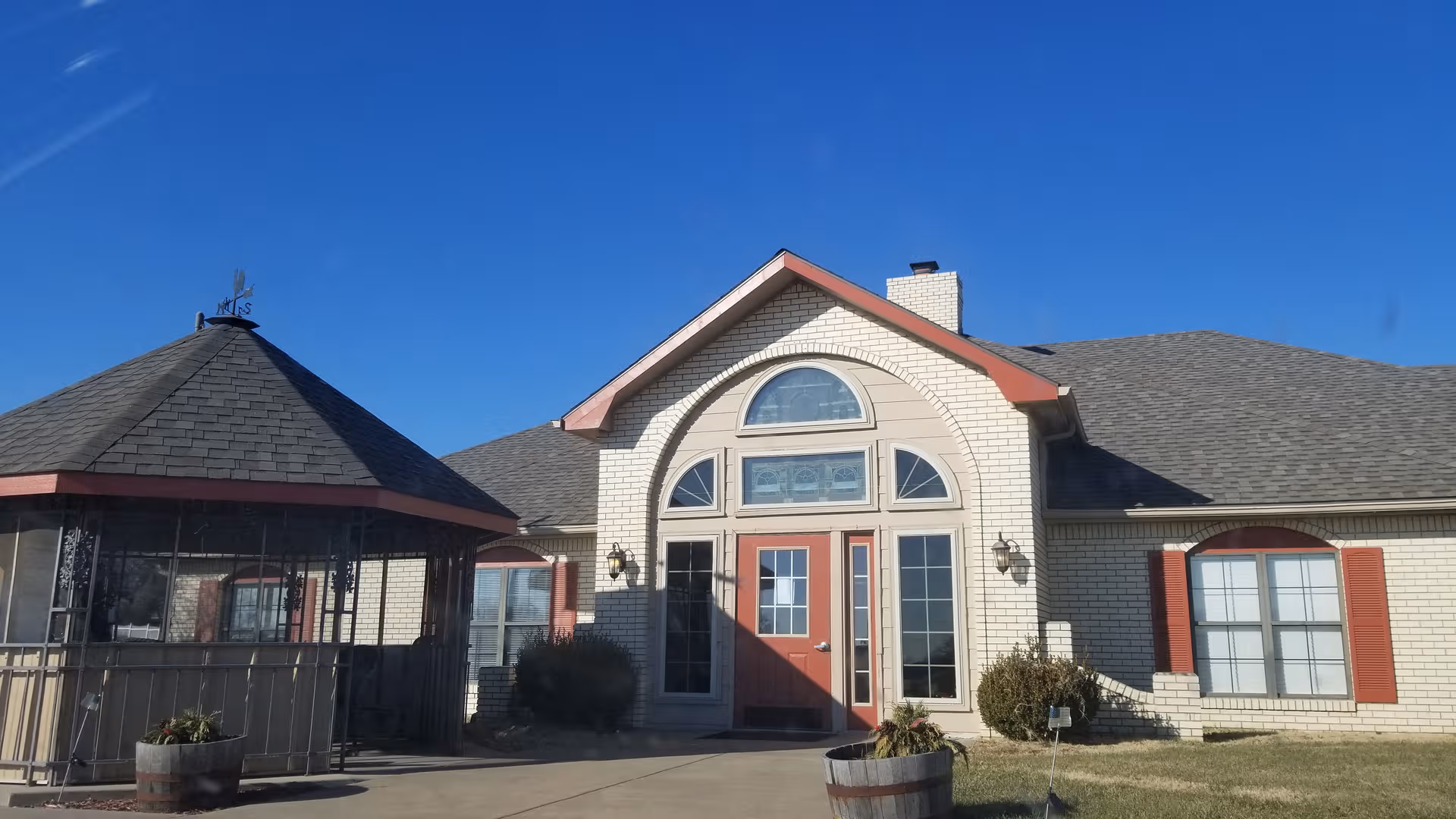 Front view of Morningstar Care Homes of Fredonia with arched windows and red entry doors