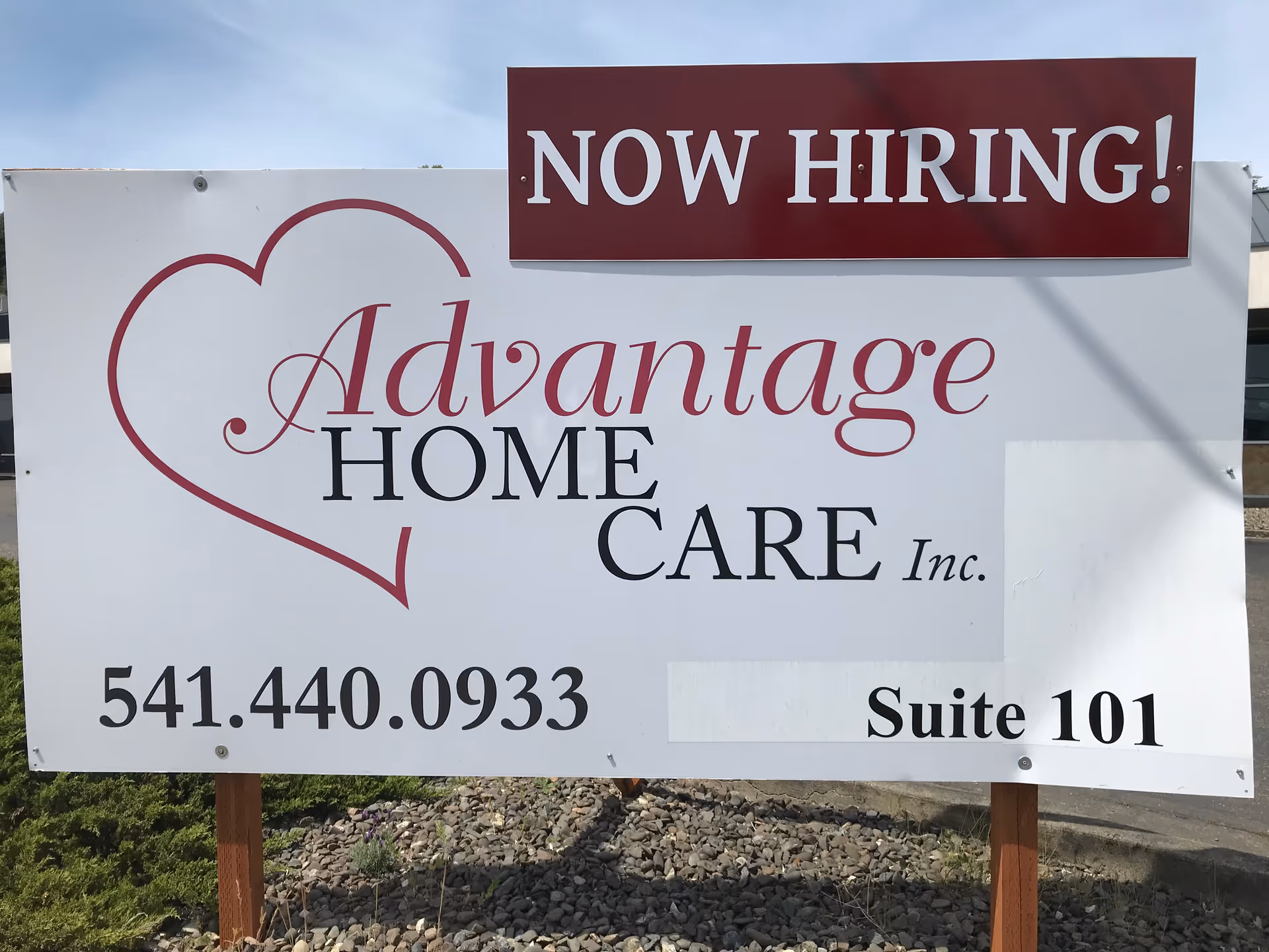 Outdoor sign advertising Advantage Home Care with a heart logo and Now Hiring banner.