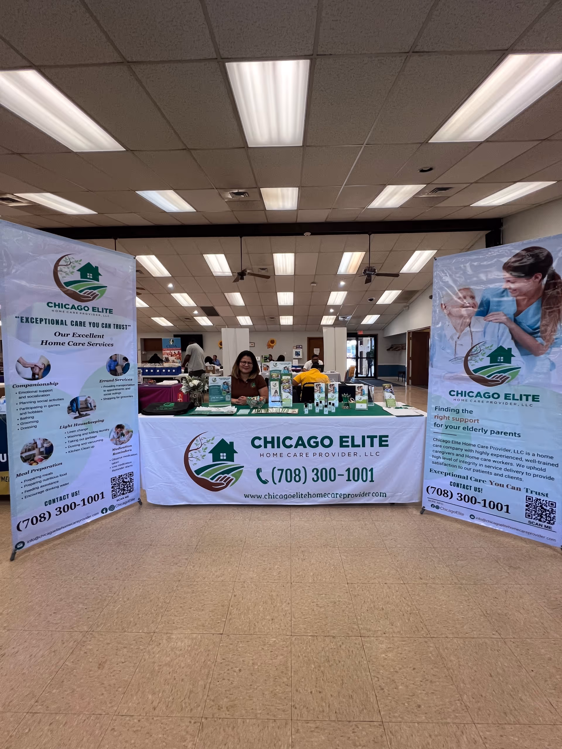 Indoor information booth with Chicago Elite banners and a staff member at a table.