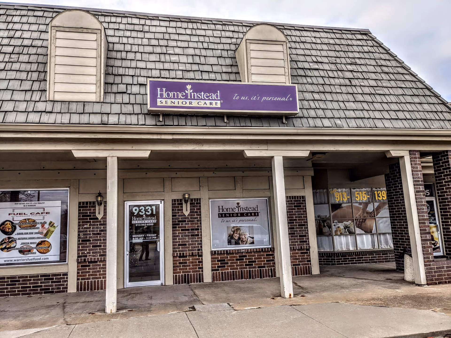 Front of a brick building with a purple Home Instead Senior Care sign.
