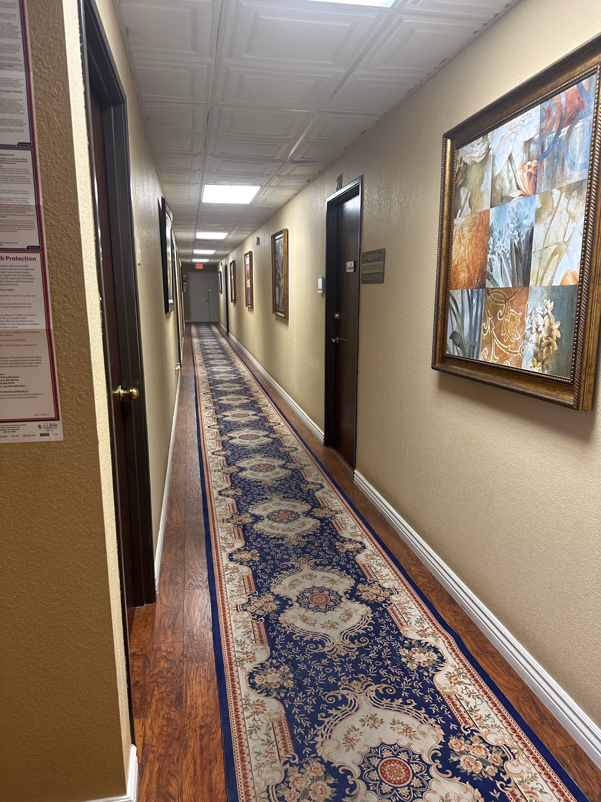 Interior hallway of senior living facility with carpet runner and wall art.