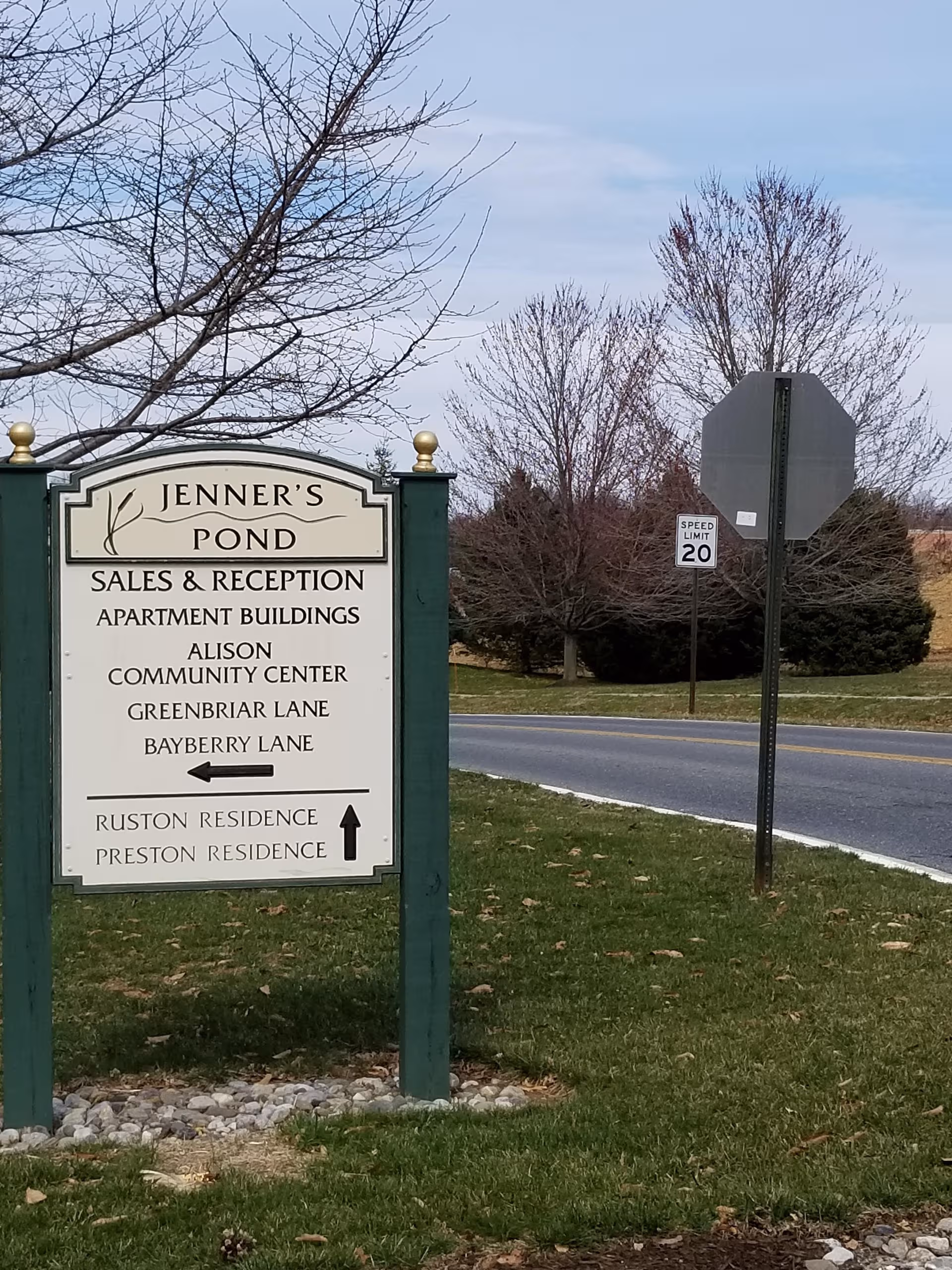 Front exterior sign for Jenner's Pond Retirement Community beside a road.