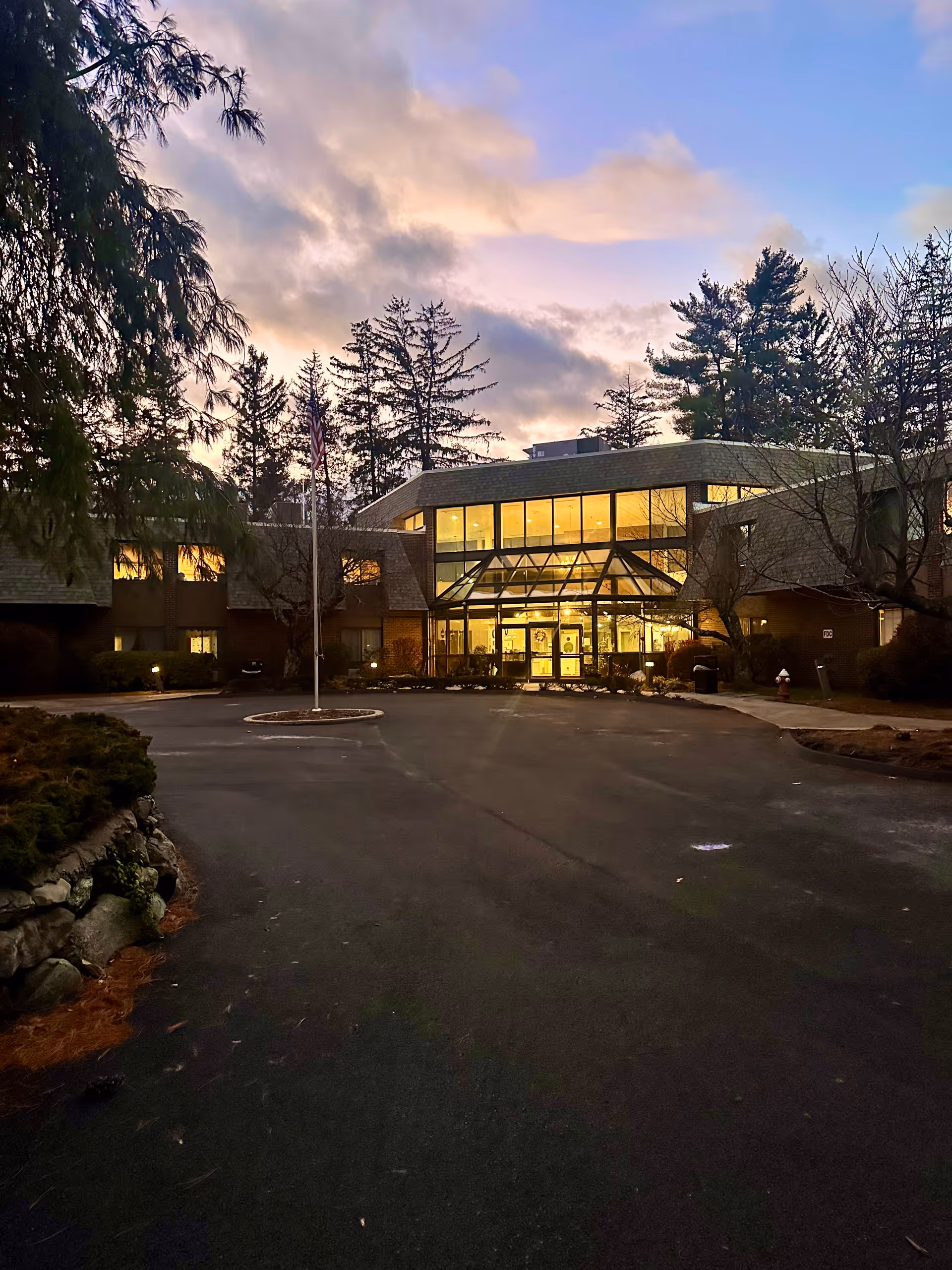 Exterior view of Vantage Health and Rehab of Wilbraham; glass entrance, driveway, and trees.