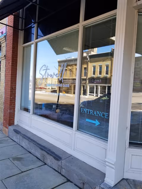 Street storefront featuring Stowell Associates signage and blue entrance arrow on window