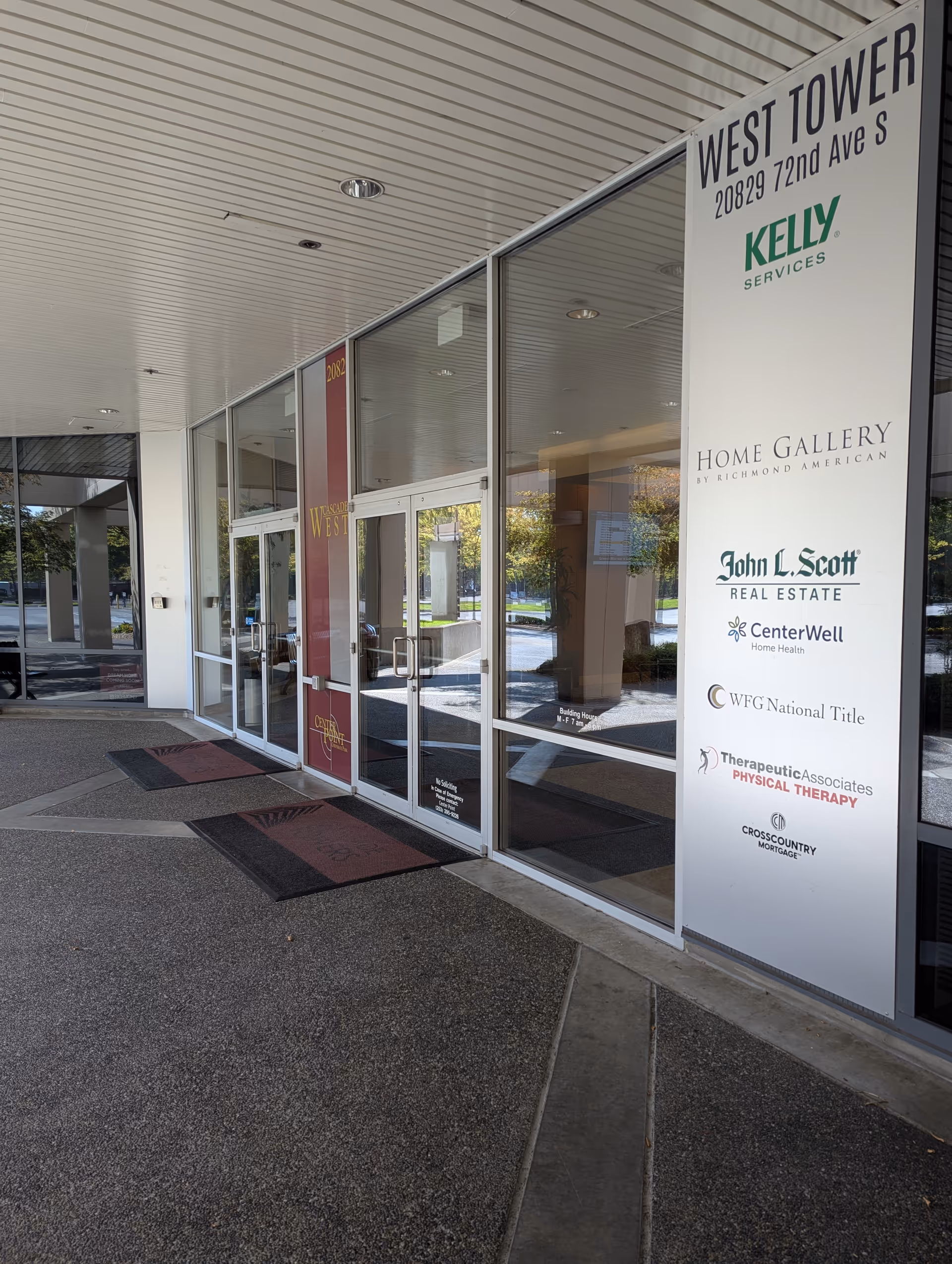 Glass storefront entrance with tall sign panel displaying West Tower and CenterWell Home Health logos.