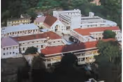 Aerial view of a multi-building senior living campus with red roofs among trees.