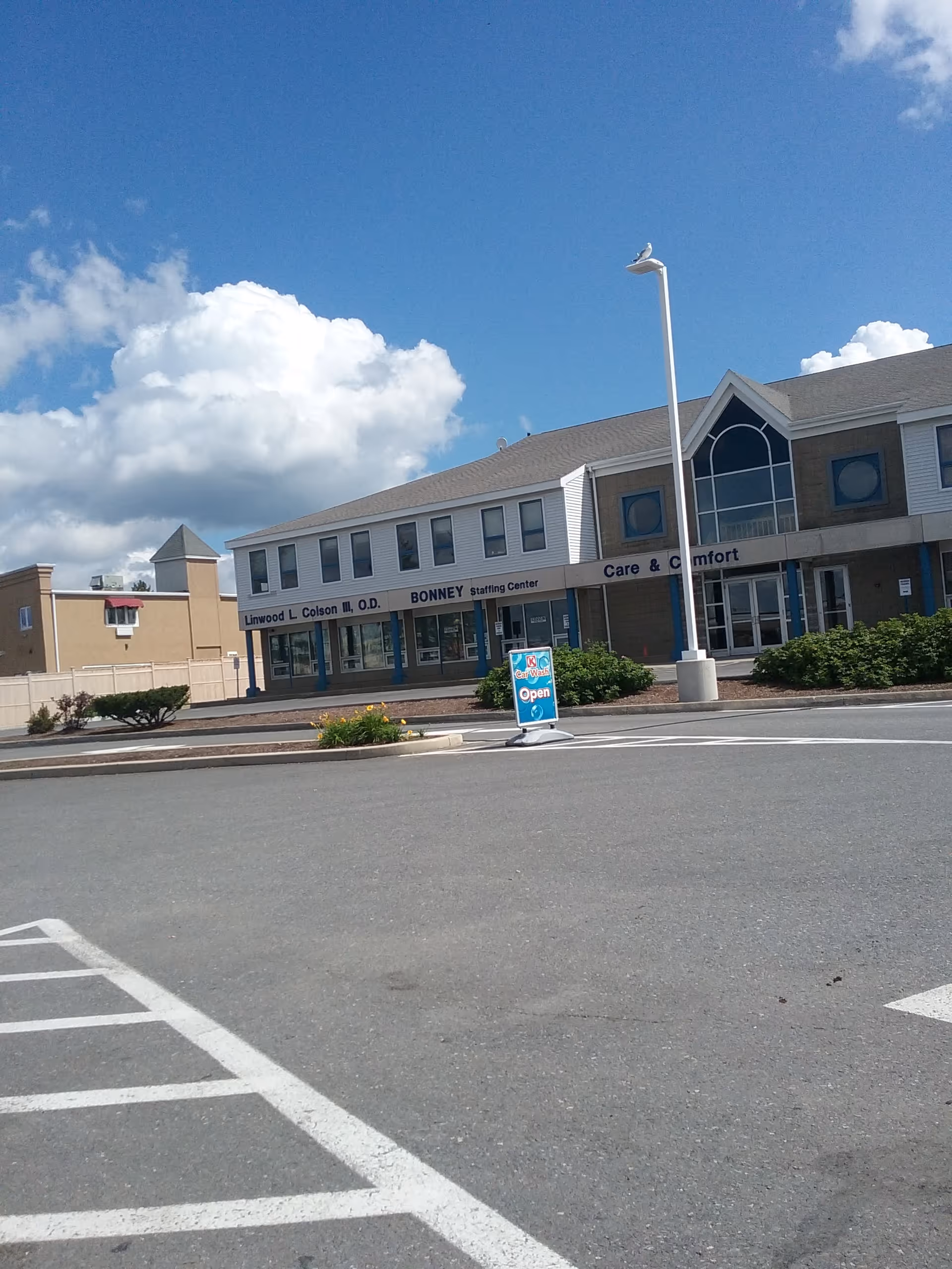 Exterior view of a senior living facility with parking and front entrance.
