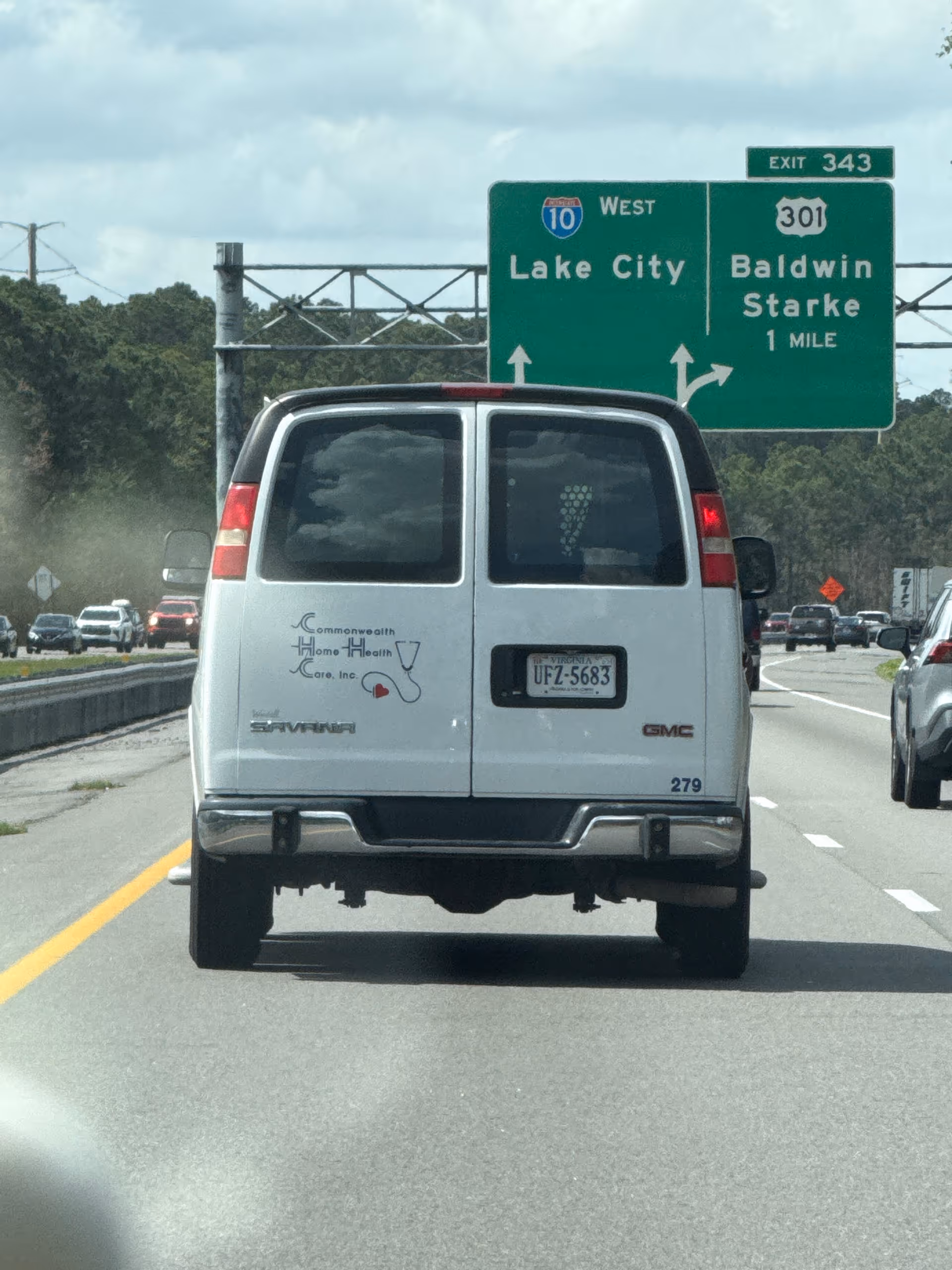 Rear view of Commonwealth Home Health Care van on a highway with green exit sign.