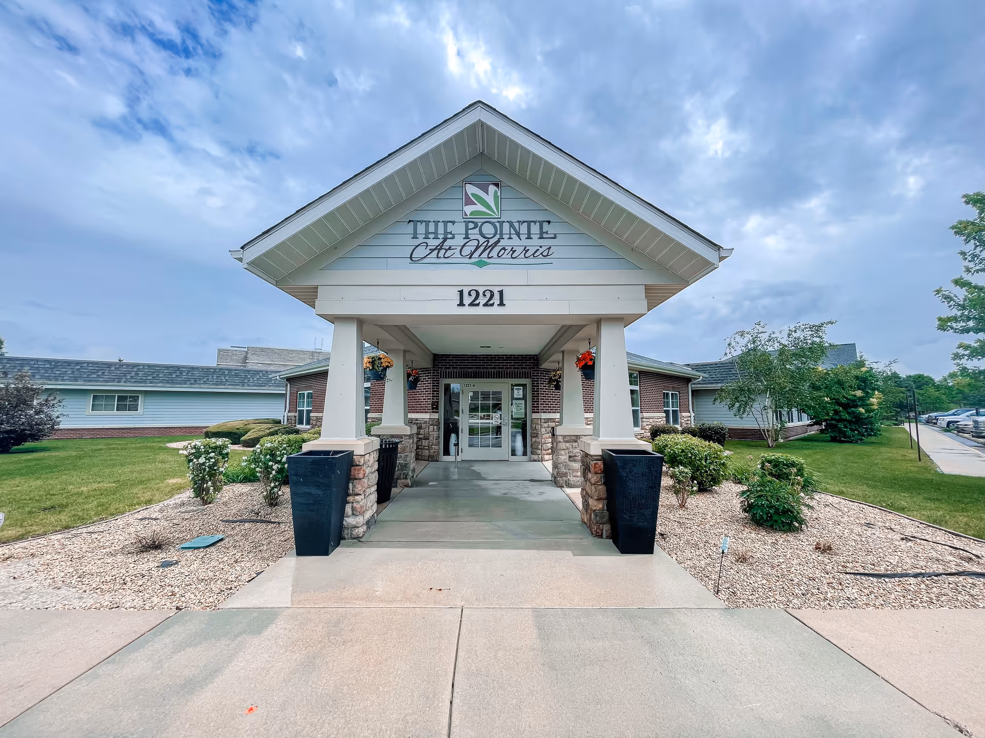 Front entrance of The Pointe At Morris senior living facility with a covered portico and address number 1221.