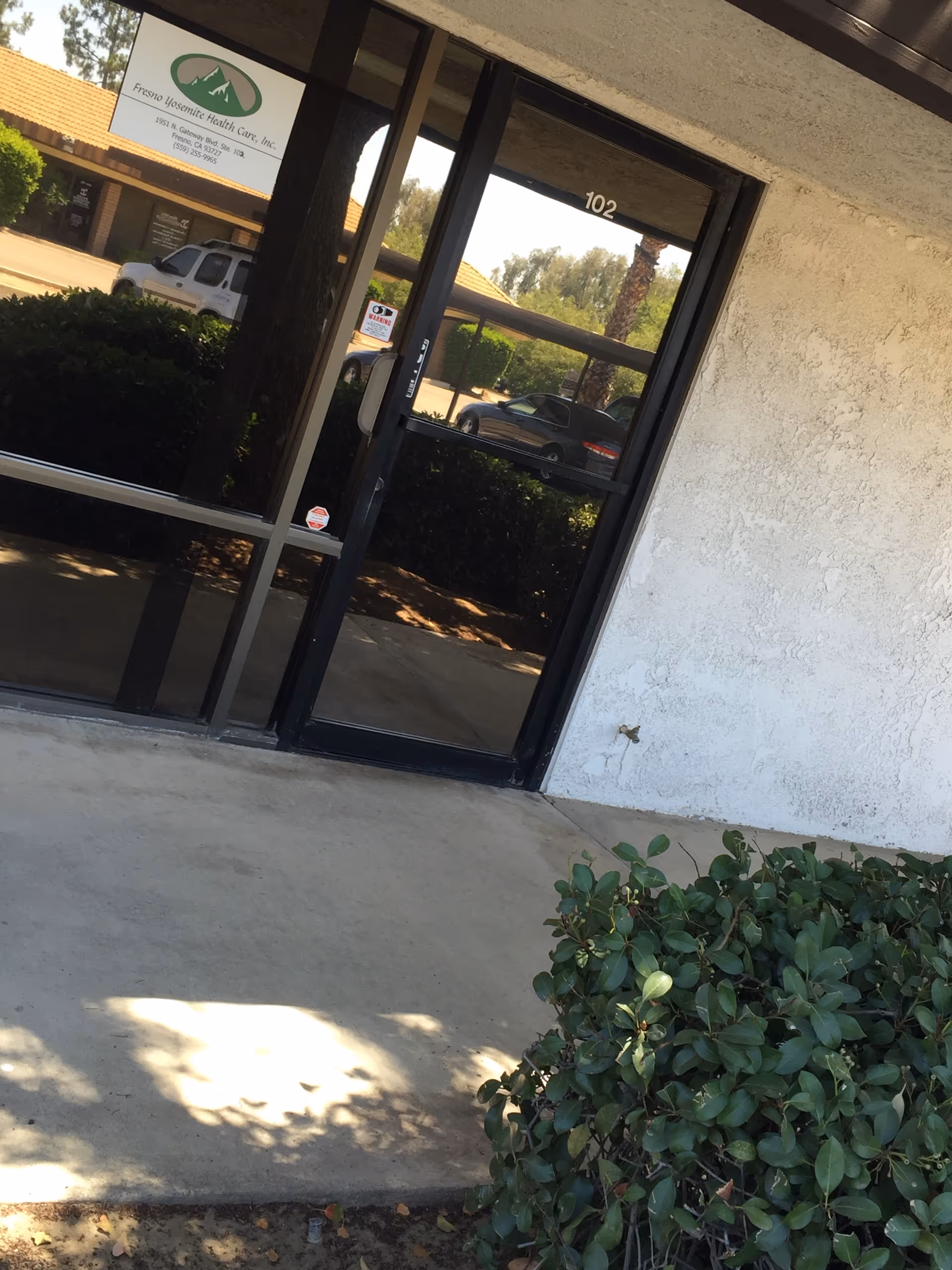 Exterior view of Fresno Yosemite Health Care entrance with glass doors.