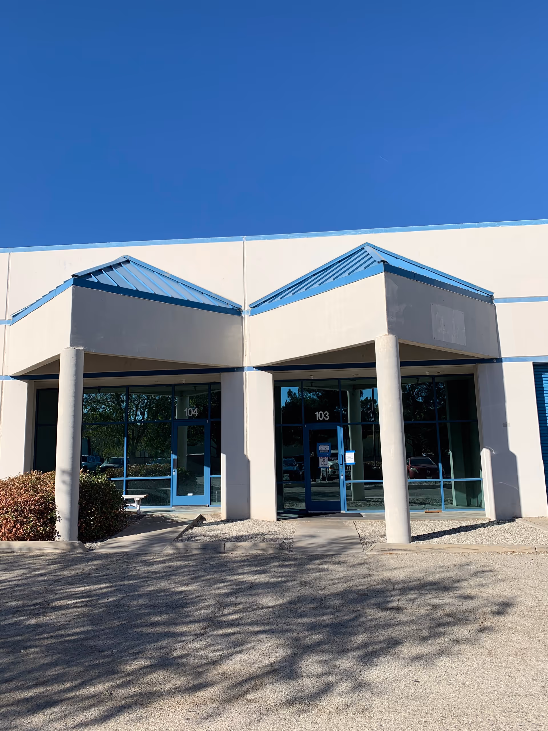 Exterior view of a senior living facility entrance with blue accents.