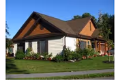 A single-story senior living facility with a brown roof and landscaped front yard.