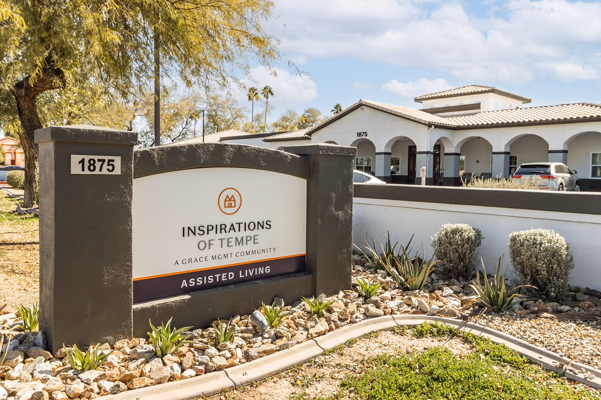 Exterior view of Inspirations Of Tempe entrance with sign and arched building facade.