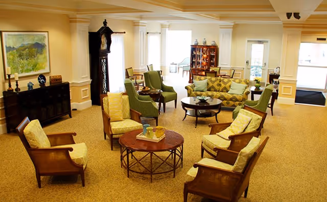 Cozy Charter Senior Living lounge with chairs, sofas, and round coffee tables.