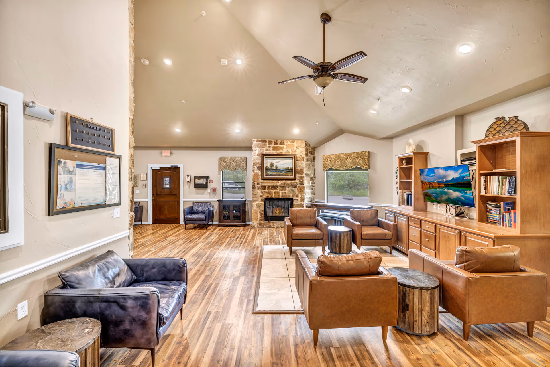 Spacious living room lounge with leather seating, a fireplace, and wall-mounted TV.