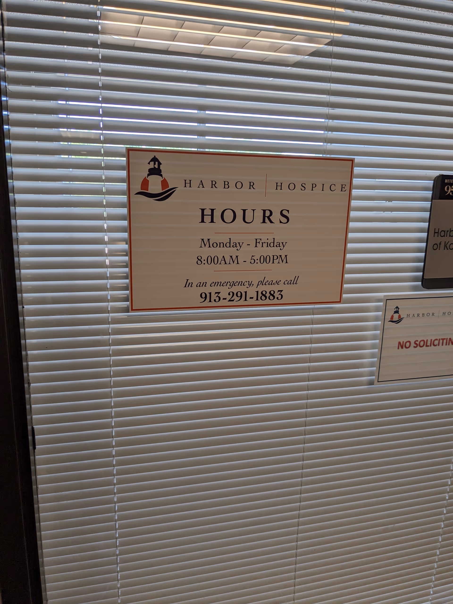 Interior hallway with closed blinds and a Harbor Hospice hours sign.