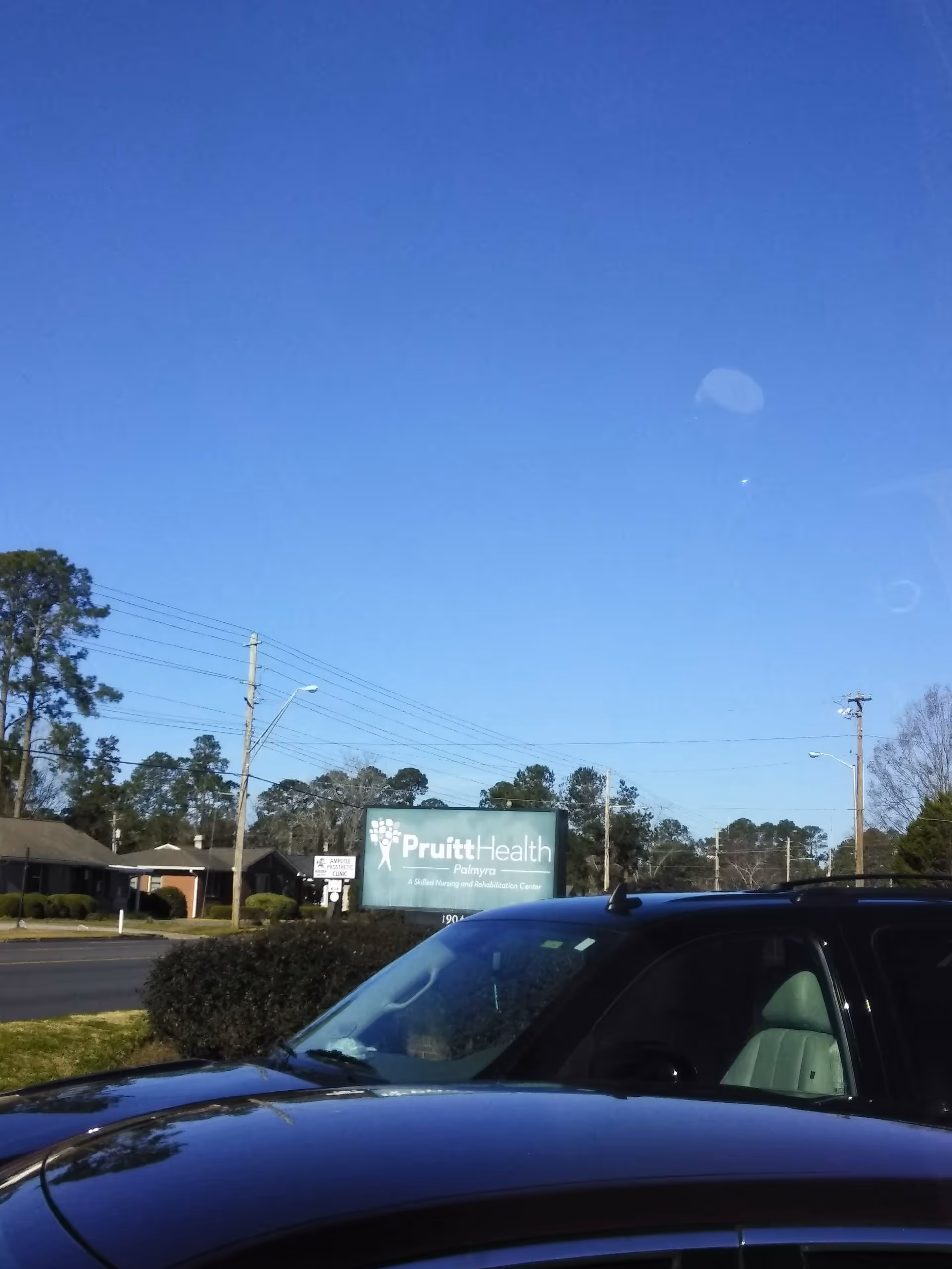 Exterior view of PruittHealth Palmyra sign with parked car in foreground