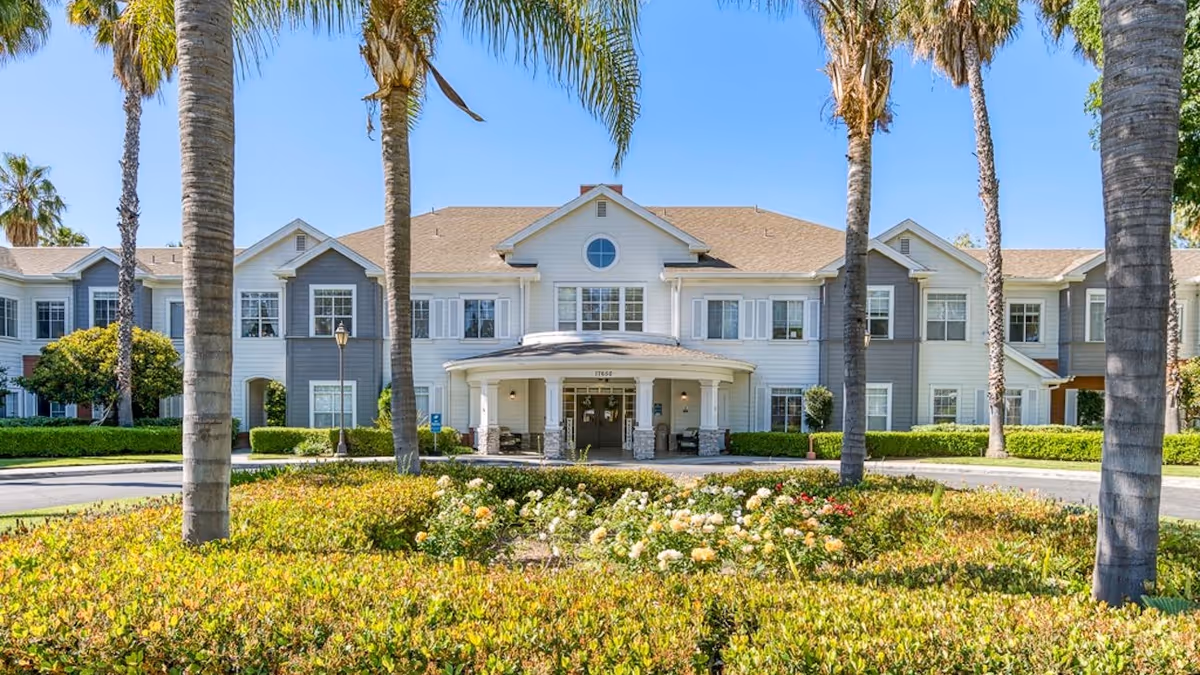 Front view of Gardens at Northridge facility with palm trees and landscaped entrance.