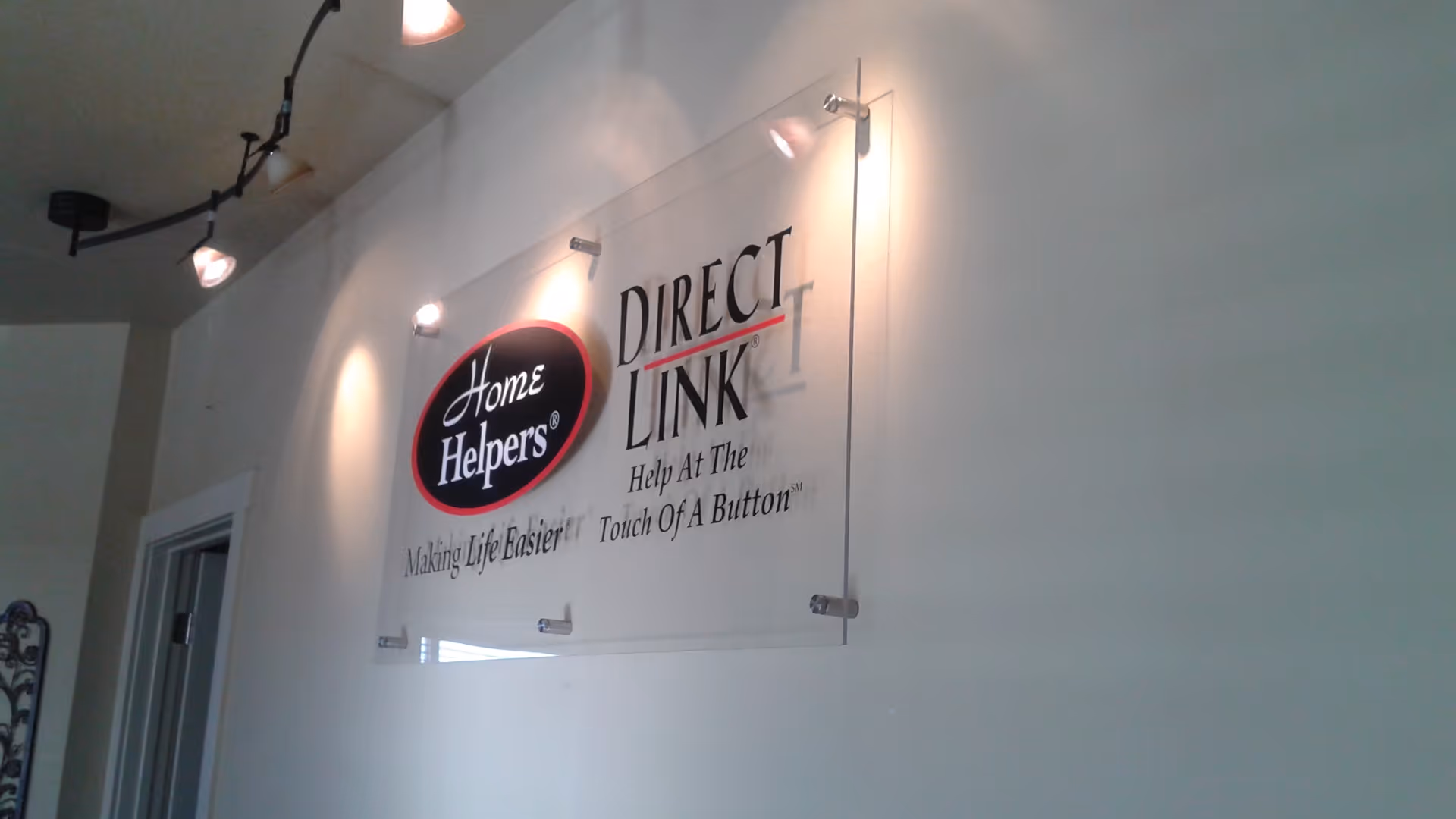 Indoor wall displays a Home Helpers Direct Link sign under spotlights.
